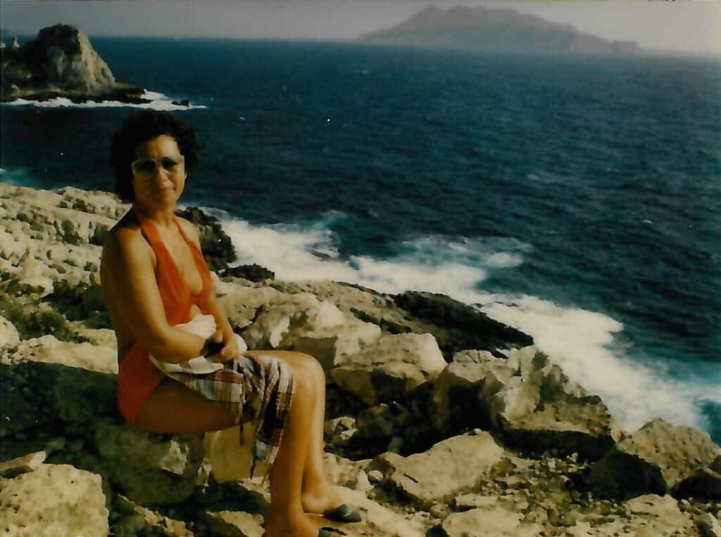 Mia madre sulla costiera levanzara. Sullo sfondo, l’isola di Marettimo (cortesia dell’autore, riproduzione riservata).